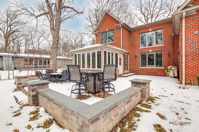 snow covered patio with a sunroom