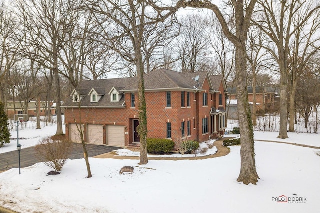 view of front of home featuring brick siding, an attached garage, and driveway