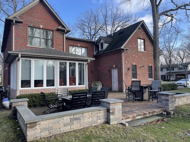 rear view of house with brick siding and a patio area