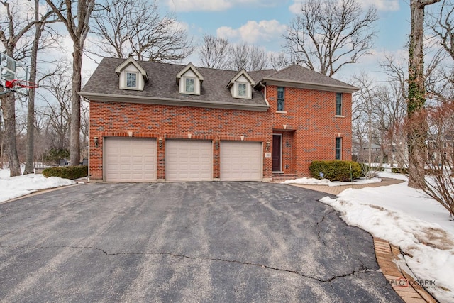 view of front of property with aphalt driveway, a garage, brick siding, and roof with shingles