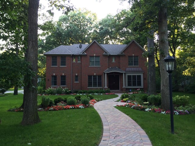 view of front of home with brick siding and a front yard