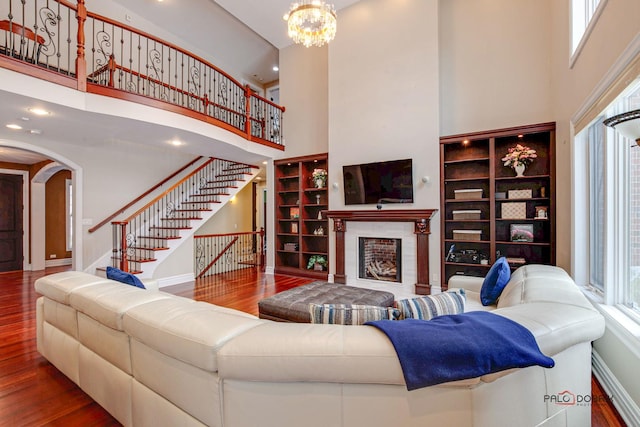 living room featuring plenty of natural light, a high ceiling, and wood finished floors