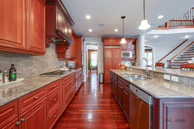 kitchen featuring dark wood-type flooring, a healthy amount of sunlight, appliances with stainless steel finishes, and a sink