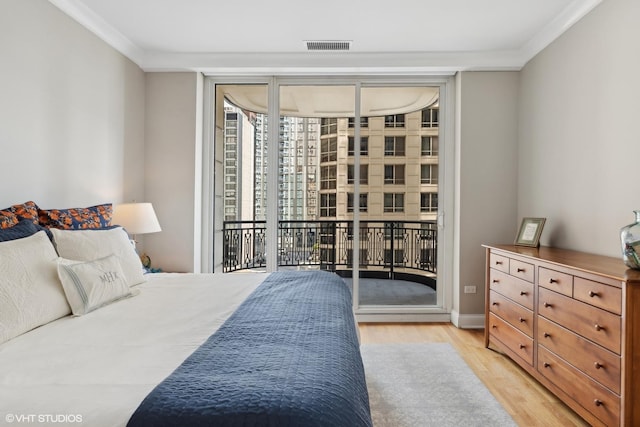 bedroom with ornamental molding, access to outside, and light wood-type flooring