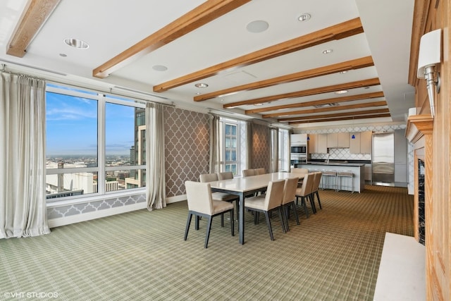 dining area with carpet floors, a wealth of natural light, and beamed ceiling