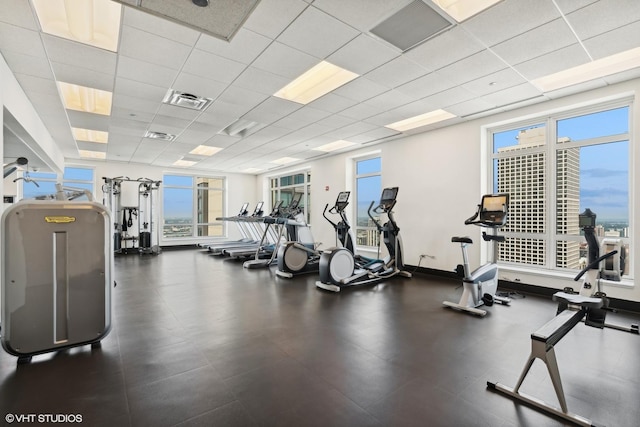 workout area with a drop ceiling and a wealth of natural light