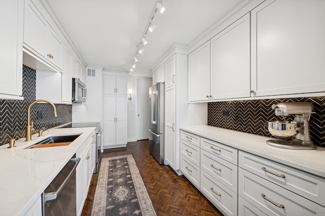 kitchen featuring light stone countertops, visible vents, a sink, appliances with stainless steel finishes, and white cabinetry