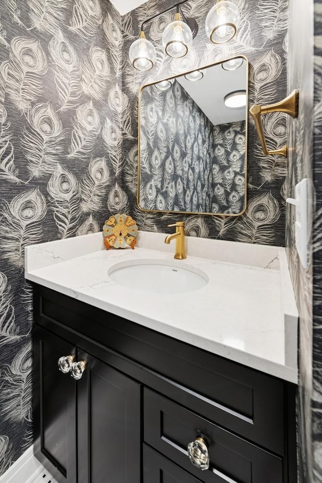 bathroom featuring wallpapered walls and vanity