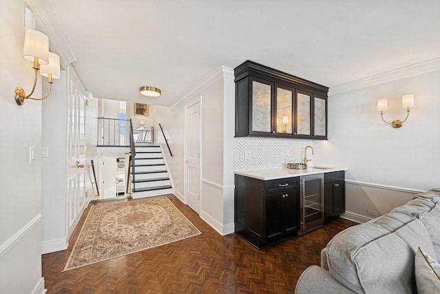 bar featuring beverage cooler, a sink, indoor wet bar, decorative backsplash, and stairs