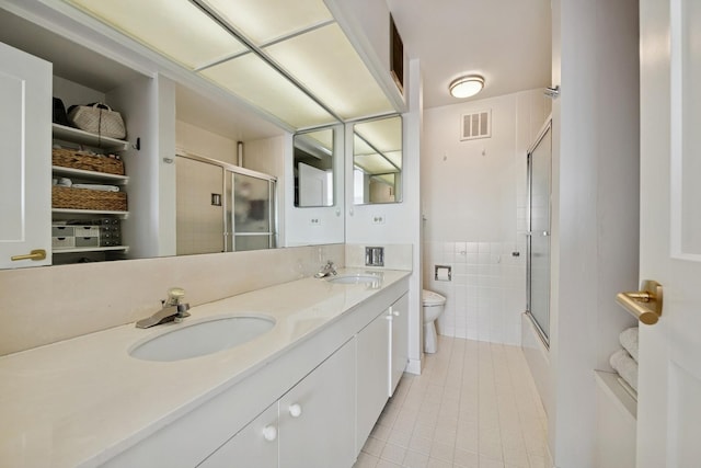 bathroom with tile patterned floors, visible vents, a shower with door, and a sink