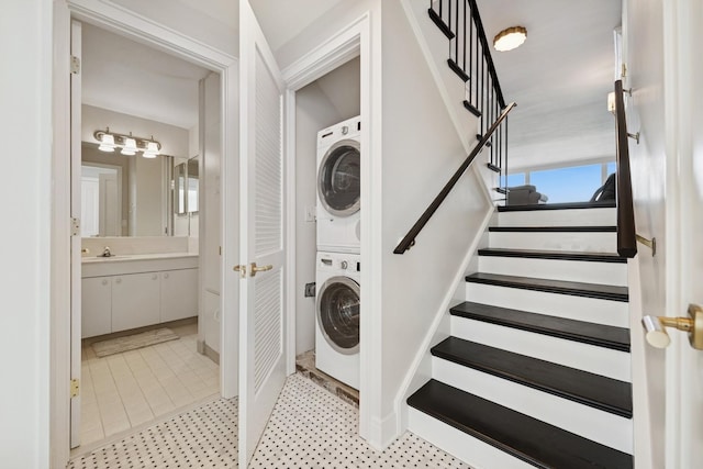 laundry area featuring laundry area, stacked washer / dryer, and a sink