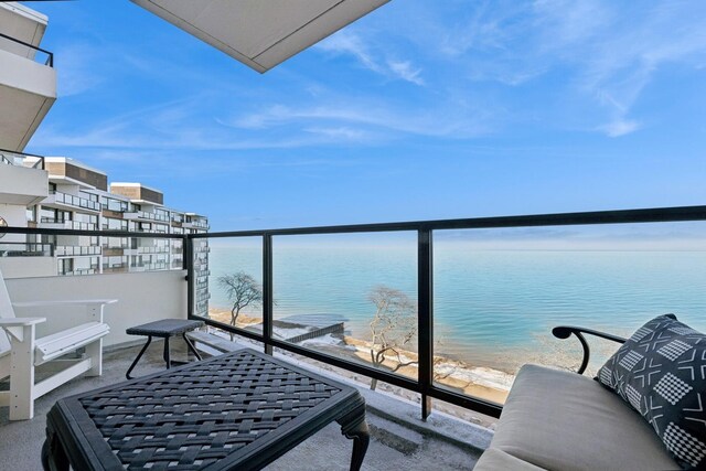 balcony featuring a beach view and a water view