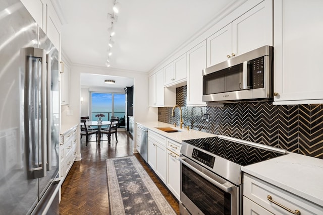 kitchen with decorative backsplash, appliances with stainless steel finishes, white cabinetry, and a sink