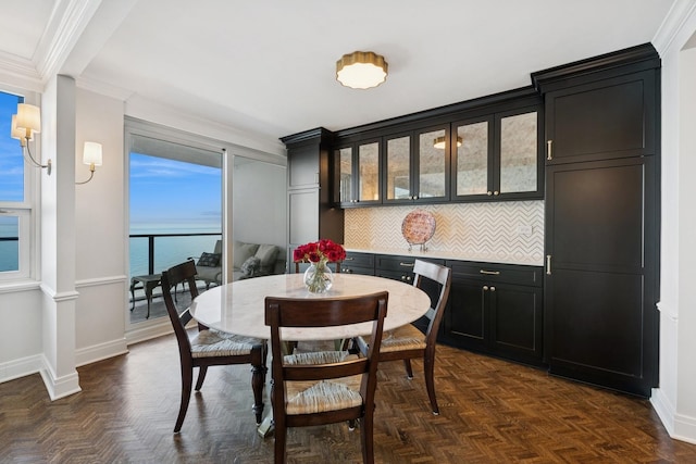 dining space with crown molding and baseboards