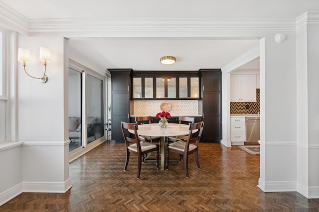 dining space featuring crown molding and baseboards