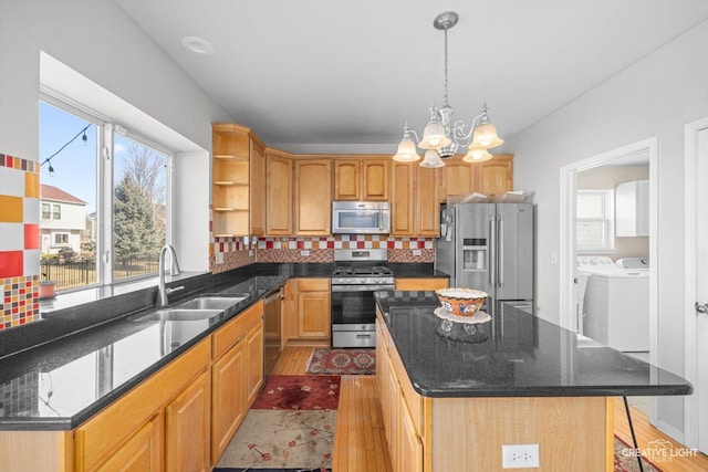 kitchen featuring a sink, backsplash, washing machine and dryer, appliances with stainless steel finishes, and open shelves