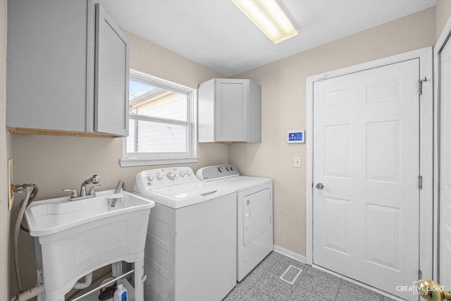 laundry area with visible vents, baseboards, washing machine and clothes dryer, cabinet space, and a sink