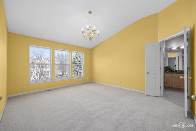 spare room featuring visible vents, light carpet, a notable chandelier, high vaulted ceiling, and baseboards