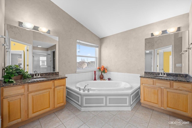 bathroom featuring a sink, lofted ceiling, a bath, and tile patterned flooring