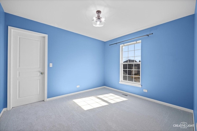 empty room with baseboards, carpet floors, and visible vents