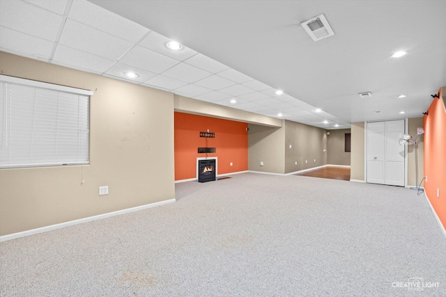 finished basement with visible vents, baseboards, a drop ceiling, carpet floors, and recessed lighting