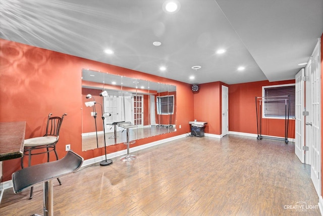 workout room featuring recessed lighting, wood finished floors, and baseboards