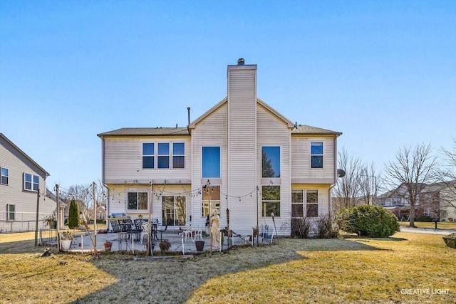 rear view of property featuring a patio area, a chimney, and a yard