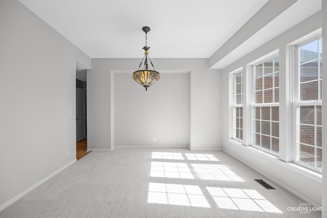 unfurnished dining area with visible vents, baseboards, and carpet