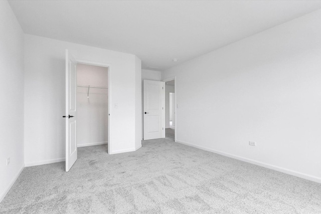 unfurnished bedroom featuring light carpet and a closet