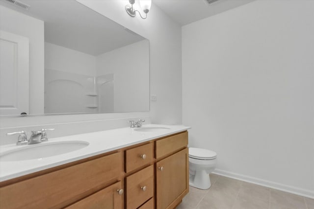 bathroom featuring tile patterned flooring, vanity, walk in shower, and toilet