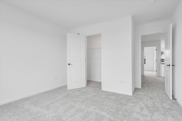 unfurnished bedroom with light carpet and a closet