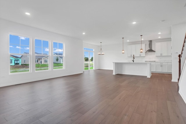 unfurnished living room featuring hardwood / wood-style floors and a notable chandelier