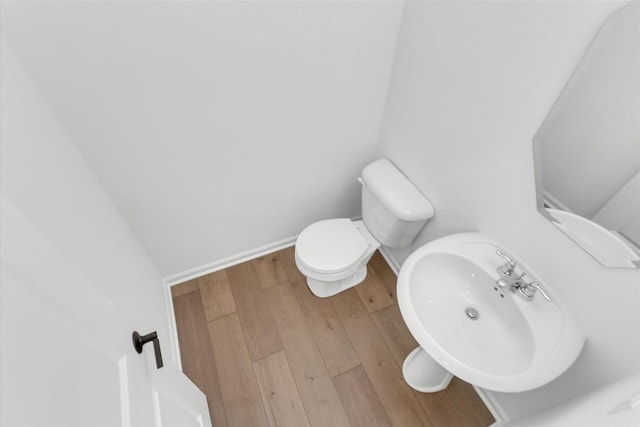 bathroom featuring wood-type flooring, toilet, and sink