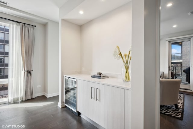 bar with dark hardwood / wood-style flooring and wine cooler