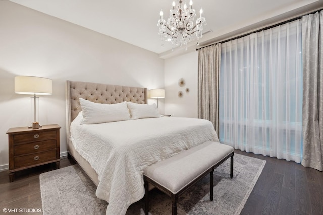 bedroom featuring an inviting chandelier and dark wood-type flooring