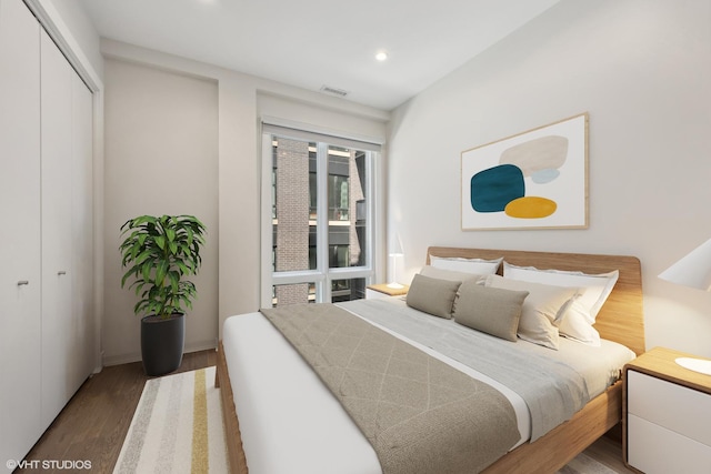 bedroom with dark hardwood / wood-style floors and a closet