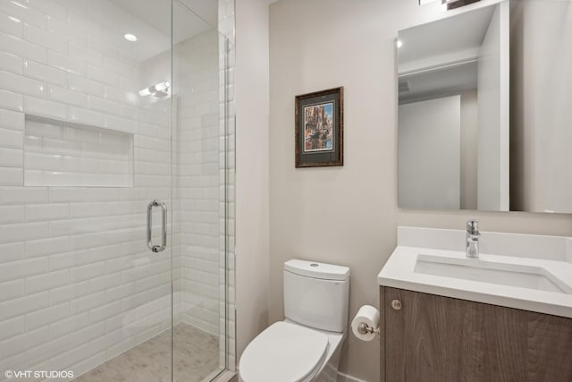 bathroom with vanity, toilet, and a shower with door