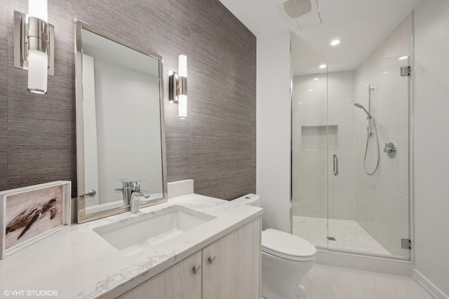 bathroom featuring vanity, toilet, and a shower with door