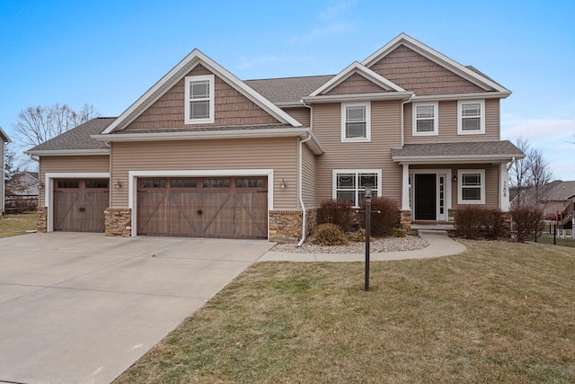 craftsman-style home with stone siding, a front yard, concrete driveway, and a garage