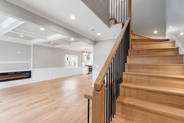 staircase with coffered ceiling, hardwood / wood-style floors, crown molding, and beamed ceiling