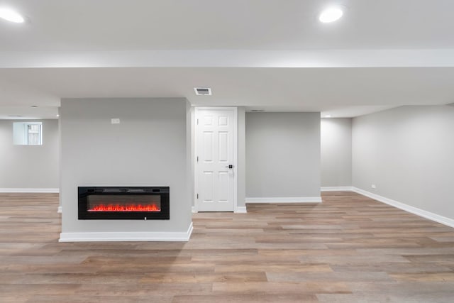 basement with light hardwood / wood-style floors