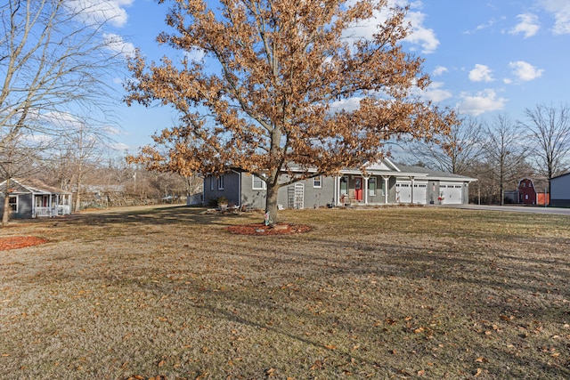 view of front of home featuring a porch, a garage, and a front lawn