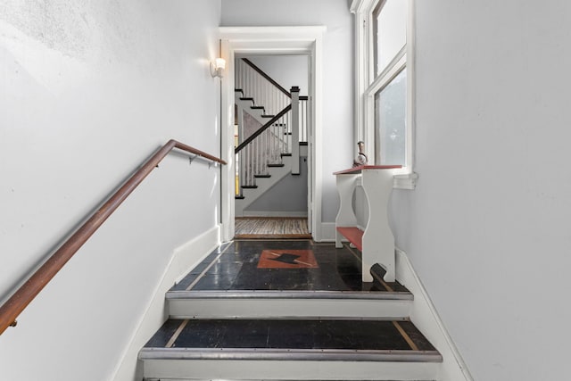 staircase with baseboards and wood finished floors