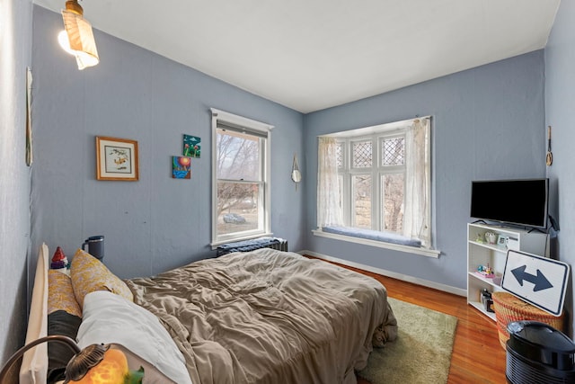 bedroom with baseboards and wood finished floors