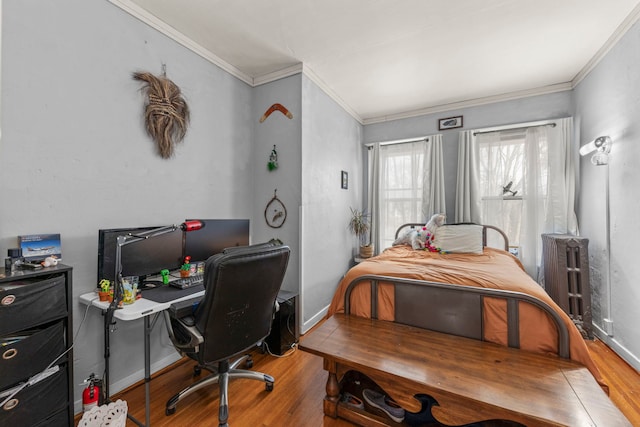 bedroom with ornamental molding, radiator, baseboards, and wood finished floors