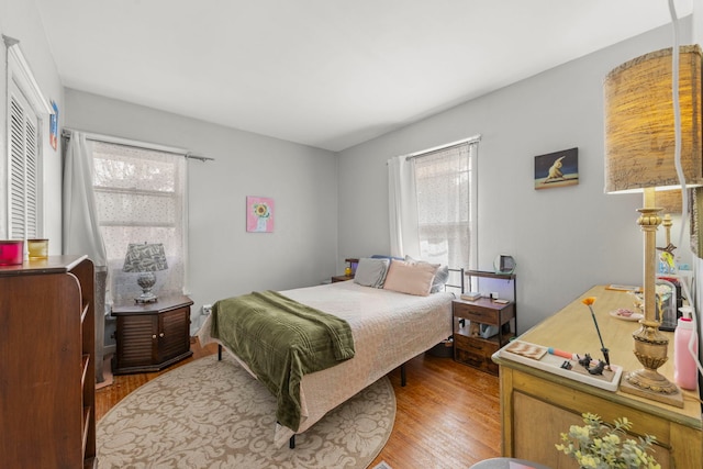 bedroom featuring multiple windows and wood finished floors