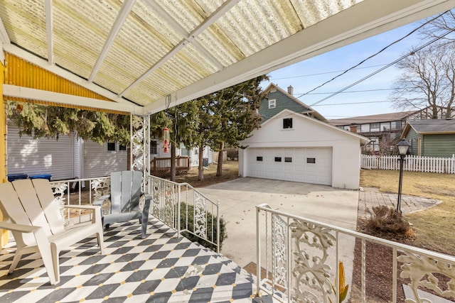 view of patio / terrace with an outbuilding, fence, and a detached garage