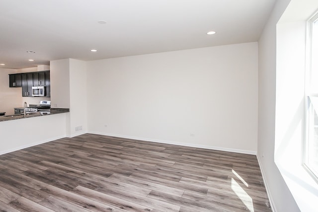 unfurnished living room with sink and dark hardwood / wood-style flooring