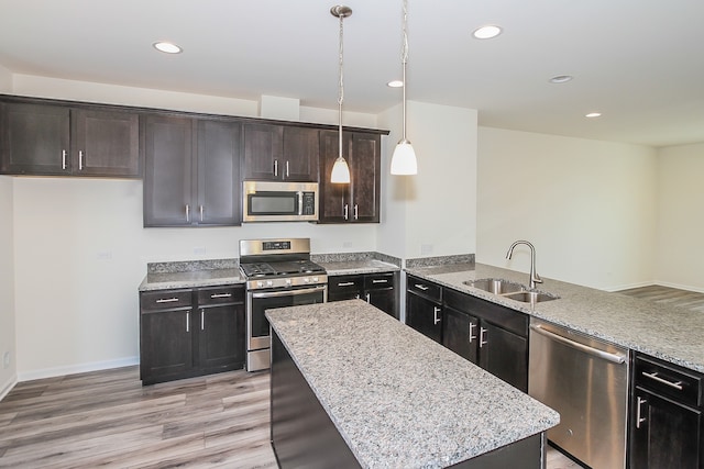 kitchen featuring pendant lighting, sink, dark brown cabinetry, and appliances with stainless steel finishes