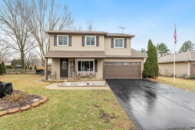 front of property featuring a garage, a front lawn, and covered porch